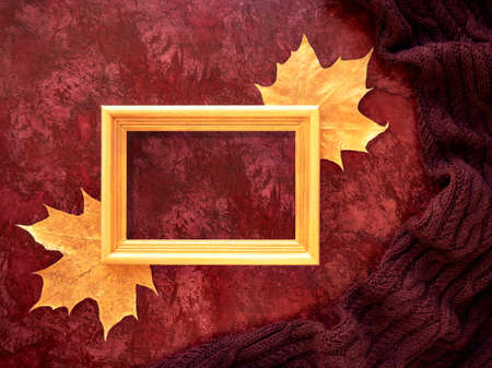 The concept of autumn. Maple leaves and text frame painted with gold paint on a background with a...