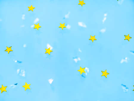 Bright gold stars on a blue background with sequins. The concept of a holiday, joy. Festive background for your projectsの写真素材