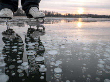Air bubbles frozen in ice, ice skating in the evening at sunsetの写真素材
