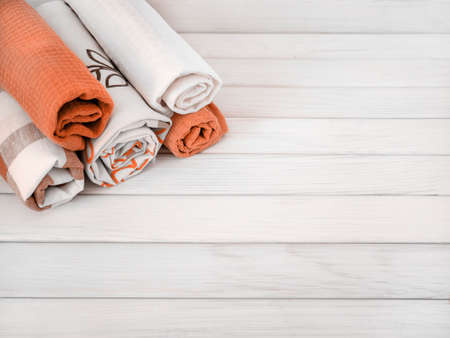 A pile of neatly folded towels on a wooden background. Production of natural textile fibers. Organic product. Natural materials.の写真素材