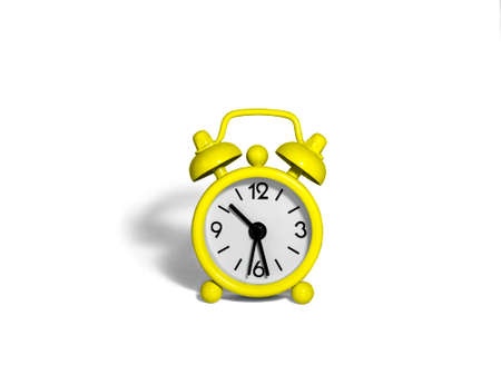 The alarm clock is bright yellow on a white background.の写真素材