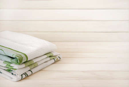 A pile of neatly folded towels on wooden background. Production of natural textile fibers.Organic...