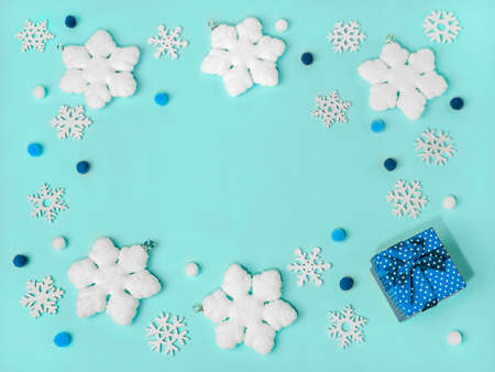 Frame of snowflakes on light blue background, pastel colors Christmas holiday composition top view,...
