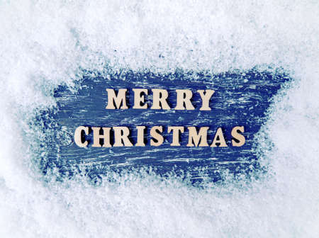 Christmas wooden background with snow and snowflake. The inscription Merry Christmas.の写真素材