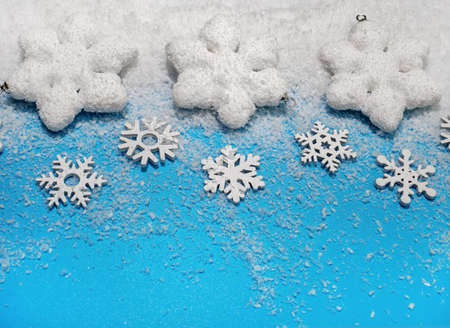 Christmas background. White decorations Christmas balls and snowflakes on soft snow, copy space, place for textの写真素材