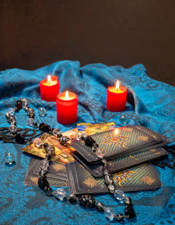 Russia, Dzerzhinsk, October 09, 2021. Cartomancy, fortune telling, predictions on tarot cards. There are witchy objects, candles on the fortune-telling table. The concept of astrology and esotericismのeditorial素材