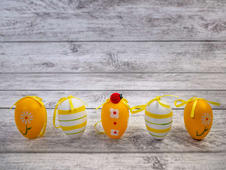 Easter eggs, ladybug on light wooden background and place to copy. greeting card for the celebration of Easterの写真素材