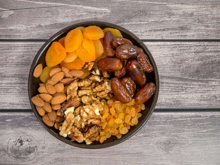 Nuts and dried fruits. Walnuts, almonds, dried apricots, raisins and dates. Healthy food and snacks. Oriental sweets.の写真素材