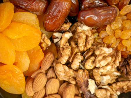 Nuts and dried fruits. Walnuts, almonds, dried apricots, raisins and dates. Healthy food and snacks. Oriental sweets.の写真素材