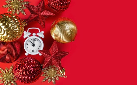 Happy New Year greeting card. Christmas and New Year decor. Christmas balls, stars and clocks on a bright red festive backgroundの写真素材