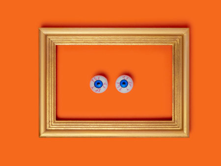 Scary and funny framed eyes on orange background for Halloween, holidays, decorations and party concept for Halloweenの写真素材