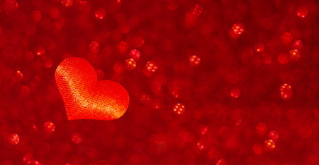 Valentines Day background. A red heart on a blurred red background with a place for text and a bokeh effect. defocusing. A symbol of love.の写真素材