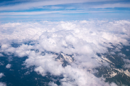 Top view from the airplane window. A wing, blue sky and white clouds. Commercial airlines. Air travel. The concept of tourismの写真素材