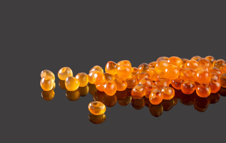 Red caviar on a dark background with a reflection. Delicious dishes, seafood. Salmon roe. Delicious gourmet food. Delicaciesの写真素材