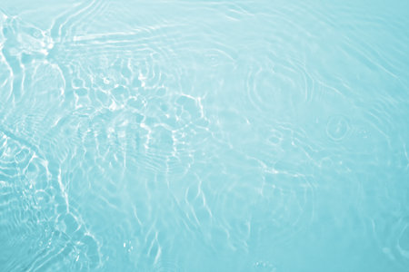 Background with clear blue water. Water background with small bubbles. transparent water surface with splashes and wave texture with ripples. Top view, a place to copyの写真素材