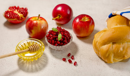 Rosh Hashanah, the Jewish New Year. Traditional symbols are tallit, apples, pomegranate, hala bread and honey on a light background. Happy Rosh Hashanah. Shana Tovaの写真素材