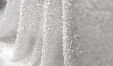Folds of fabric for a wedding dress in close-up with a place for text. A chic background of white lace textiles with beads and sequins.の写真素材