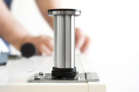 Kitchen installation, worker twists legs for box. Man's hand repairs furniture in the house