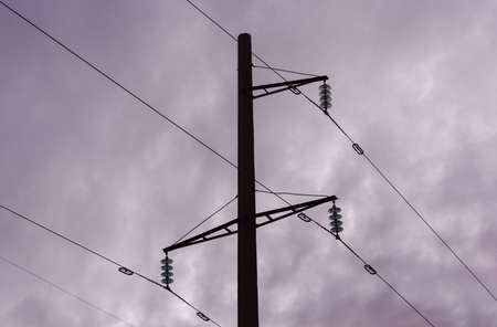 Electric pole and electric cables at sunset. silhouette.