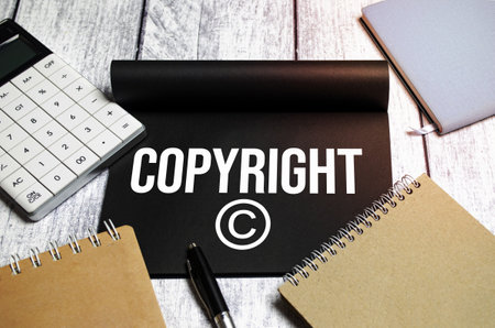 concept word Copyright text on black notepad and calculator, pen and notepadsの写真素材