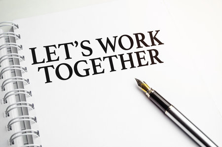 let's work together words on white notepad and penの写真素材