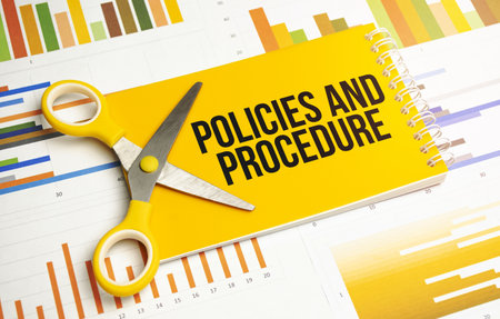 policies and procedure word written on yellow notebook and chartsの写真素材