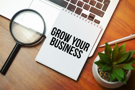 GROW YOUR BUSINESS writing text post it paper in office on laptop computer keyboardの写真素材