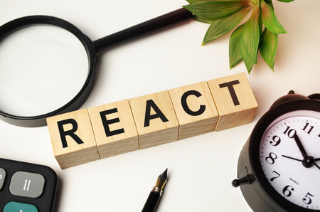 REACT - word of wooden blocks with a letter on white backgroundの写真素材