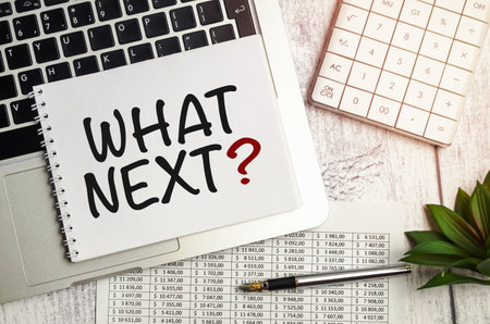 WHAT NEXT text on notepad and laptop on wooden backgroundの写真素材