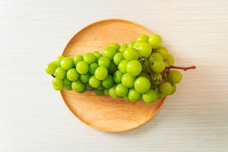 beautiful and fresh green grape on wood plateの写真素材