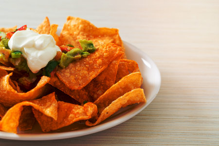 Mexican nachos tortilla chips with jalapeno, guacamole, tomatoes salsa and dip