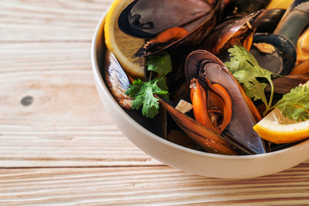 fresh mussels with herbs in a bowl with lemon