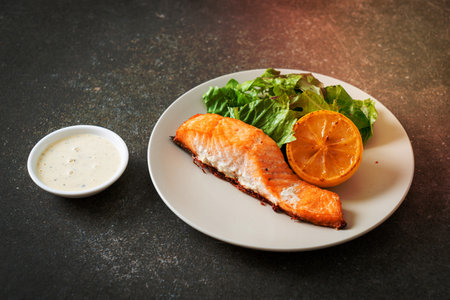homemade fried salmon steak with lemon and vegetable - healthy food styleの写真素材