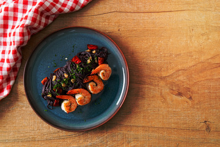 stir-fried black spaghetti with garlic and shrimps on plateの写真素材