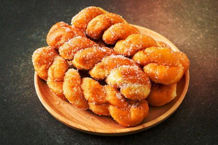sugar doughnut in spiral shape on wooden plate