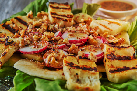 Apple salad, lettuce leaves and halloumi cheese on wooden background.の写真素材