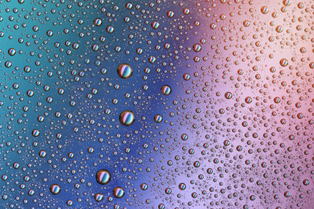 Drops on glass of different sizes and colors on a colored background, texture.