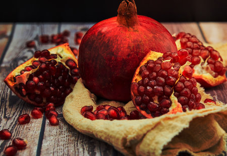 Ripe pomegranate fruit on old brown wooden vintage background.の写真素材