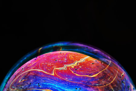 Virtual reality space with abstract multicolor psychedelic planet. Closeup Soap bubble like an alien planet on black background.の写真素材