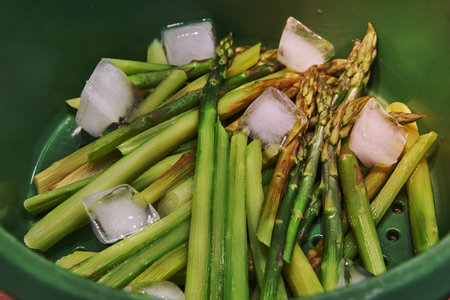 Roasted asparagus in bowl with ice cubes is ready for cooking.の写真素材