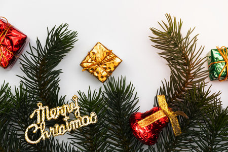 Merry Christmas card made of fir branches, gift boxes, red decoration, sparkles and confetti on white background. Xmas and New Year holiday, bokeh, light. Flat lay, top viewの写真素材