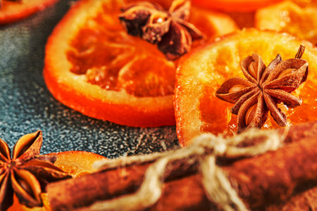 Slices of dried oranges or tangerines with anise and cinnamon, on a blue background. Vegetarianism and healthy eating.の写真素材