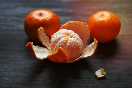 clementines or tangerines or mandarin oranges on rustic wooden table with selective focusの写真素材