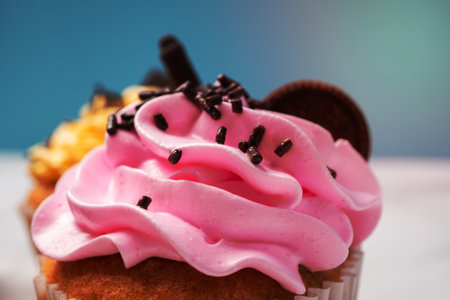 Delicious homemade cupcakes with Colorful cream and topping with candy and Chocolate Cookies....