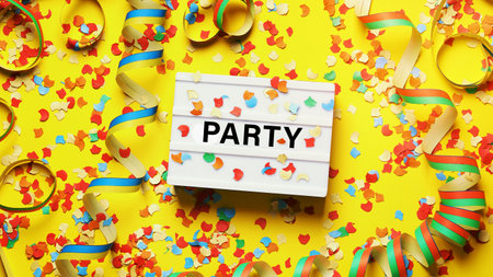 party celebration flat lay with confetti streamers and text on lightboxの写真素材