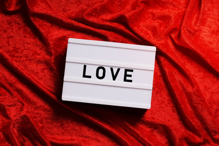 love, word on lightbox or light box sign on red velvet backgroundの写真素材