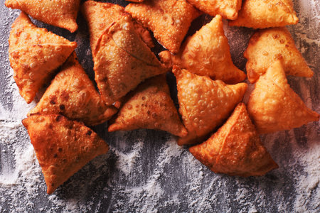 A pile of baking samosas on a floured table. horizontal top view close-upの写真素材