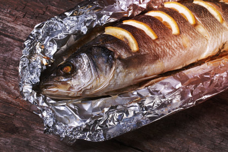 Sea bass with lemon baked in foil. closeup. horizontalの写真素材