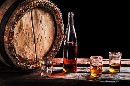 Three glass of aged whisky and bottle