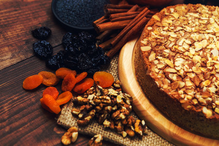 Homemade pie with poppy seeds and almond flakes on rustic wooden table